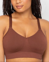 Woman wearing a brown sports bra against a plain background