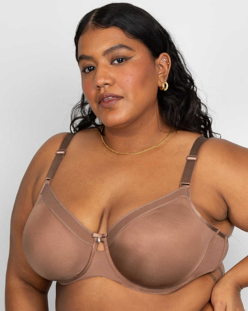 Woman wearing a brown bra against a plain background