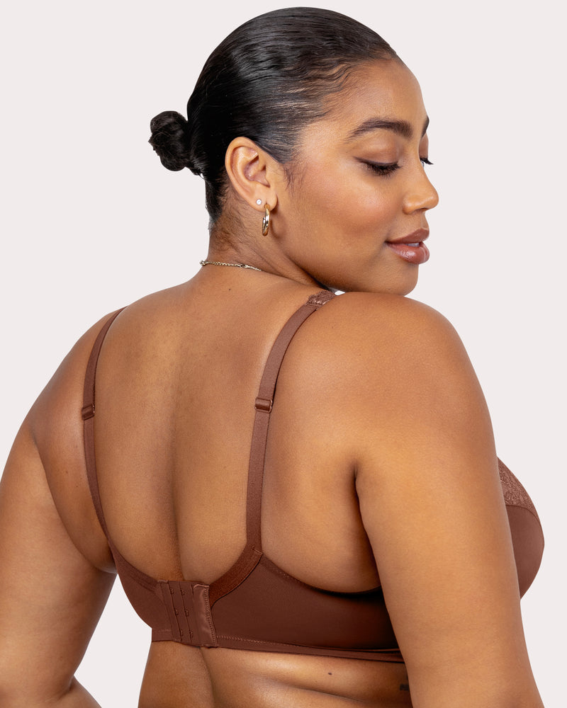 Woman wearing a brown bra against a plain background